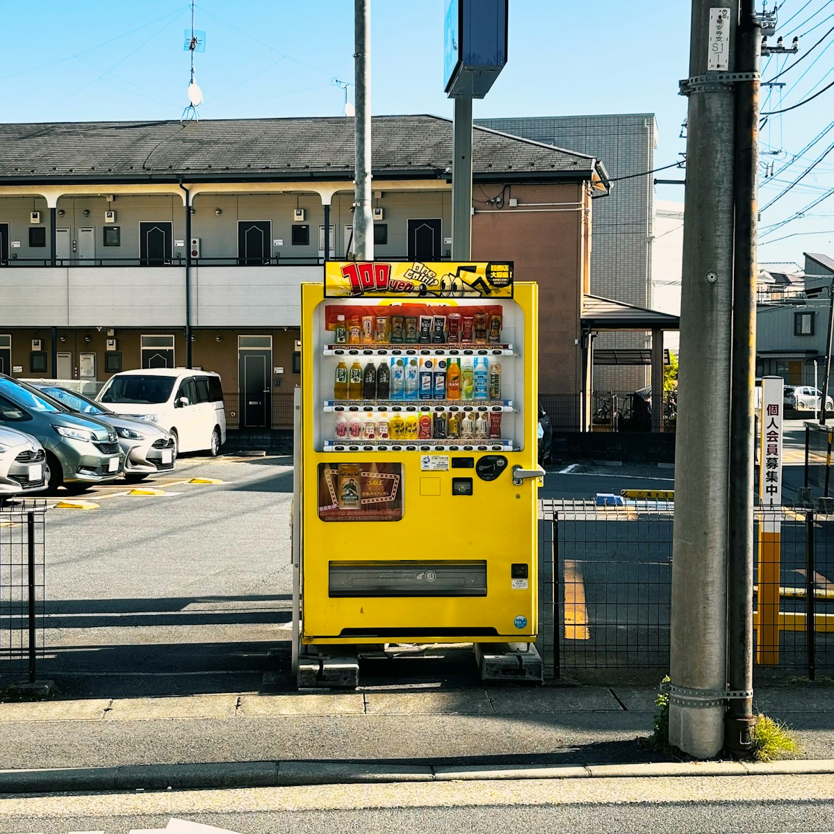 a yellow vending machine sitting on the side of a road